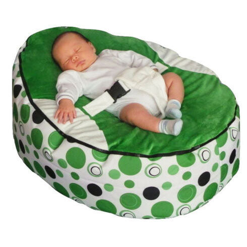 Baby lying on a green and white patterned bean bag chair.