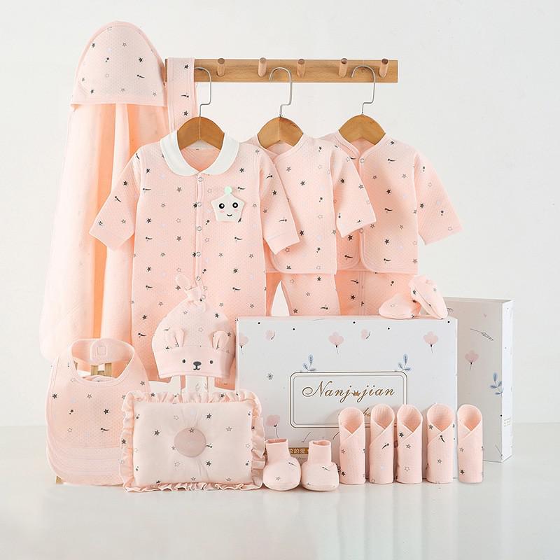 Baby clothing set with pink outfits, accessories, and a box on a white background