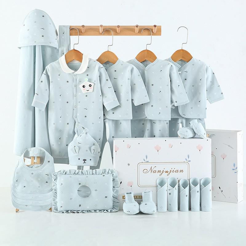 Collection of baby clothing and accessories on hangers with a branded box in the background.