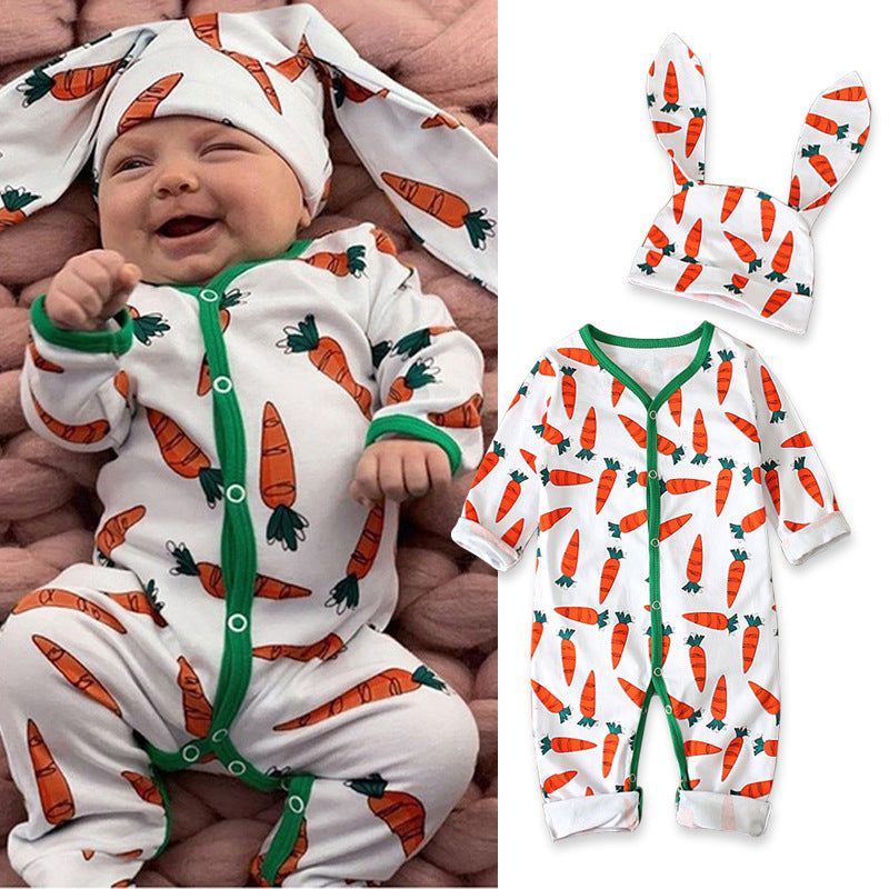 Baby in carrot-patterned onesie and hat with matching outfit on a plain background