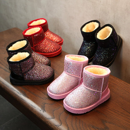 Children's glittery boots in various colors on a wooden surface.