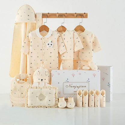 Baby clothing set with shirts, pants, and accessories displayed on a rack against a white background.