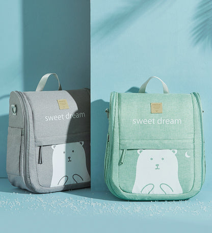 Two backpacks, one gray and one green, with a bear design and 'sweet dream' text on a light blue background.