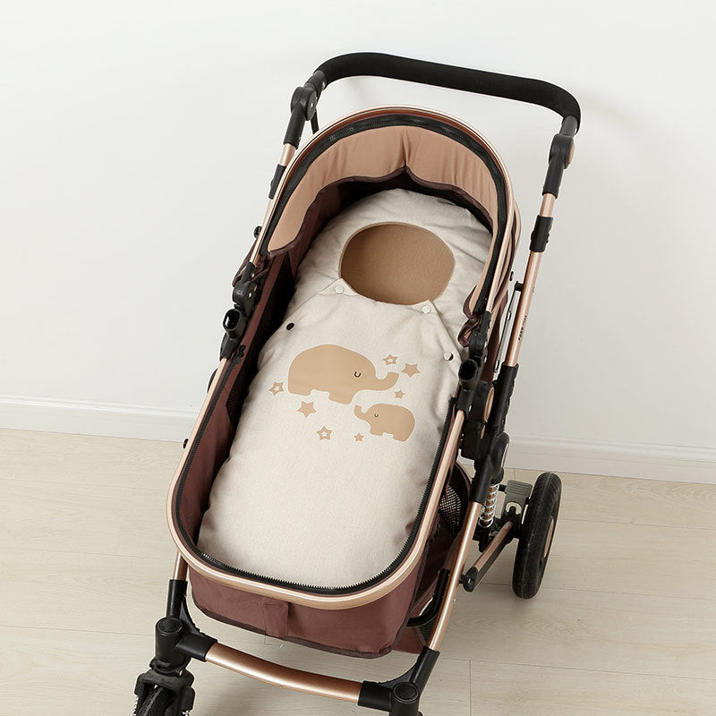 Baby stroller with a baby bag featuring elephant designs on a light wooden floor.
